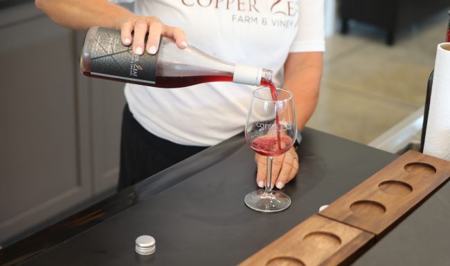 Pouring a glass of Copper Leaf wine for a tasting flight